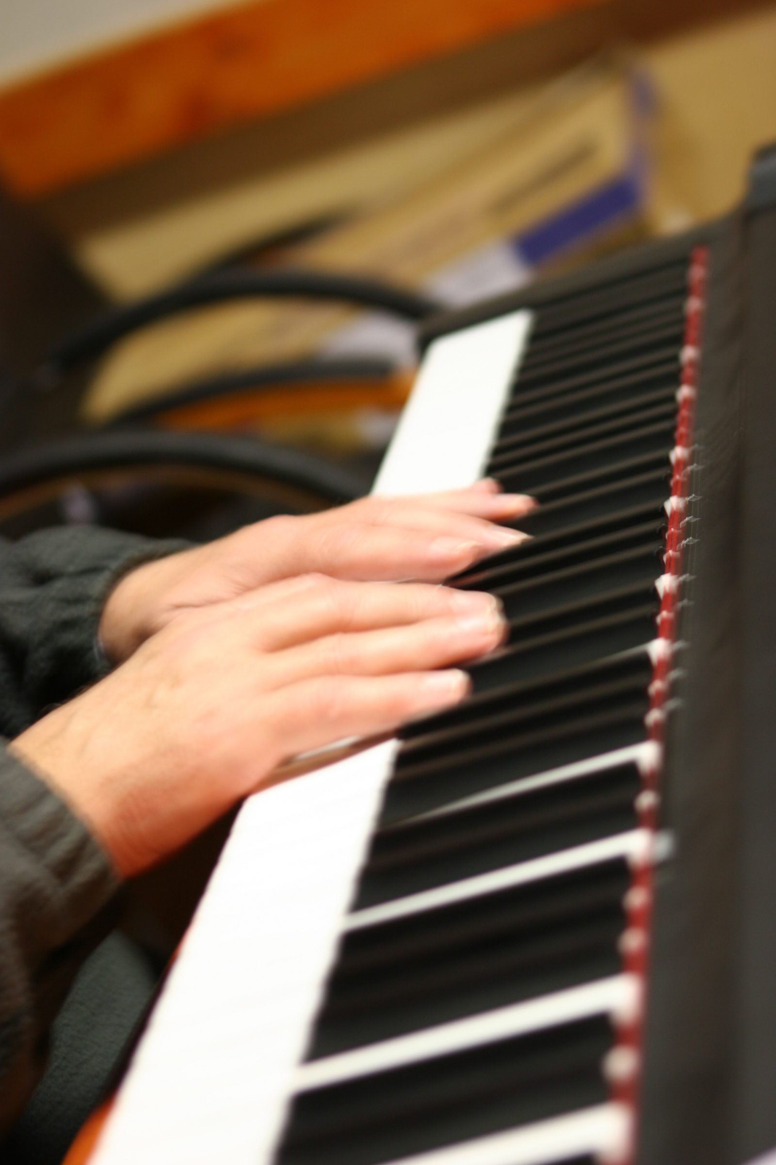 Hände auf den Tasten eines Keyboards im Aufnahmeraum